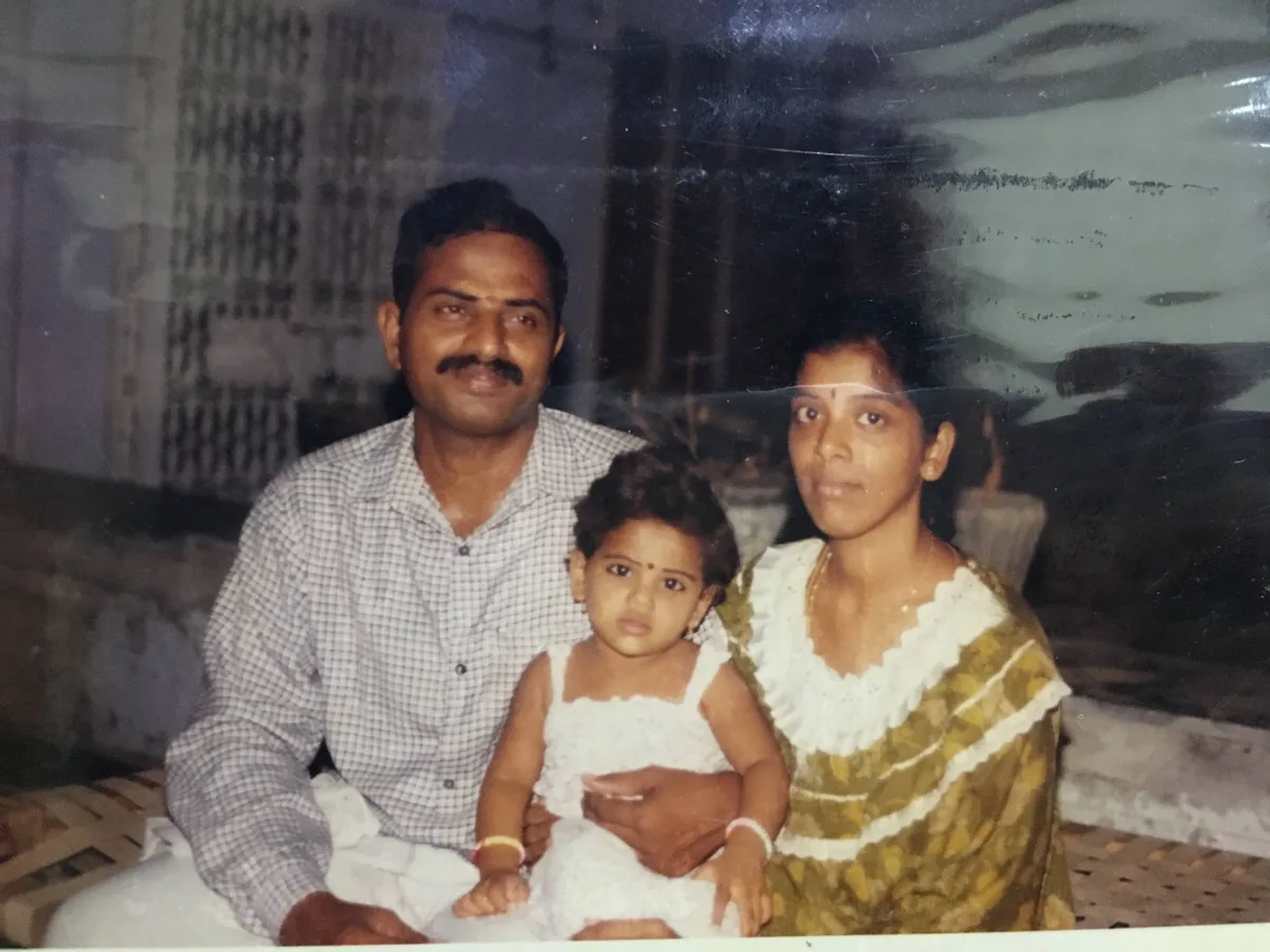 An old family portrait: a father and mother seated with their small child between them.