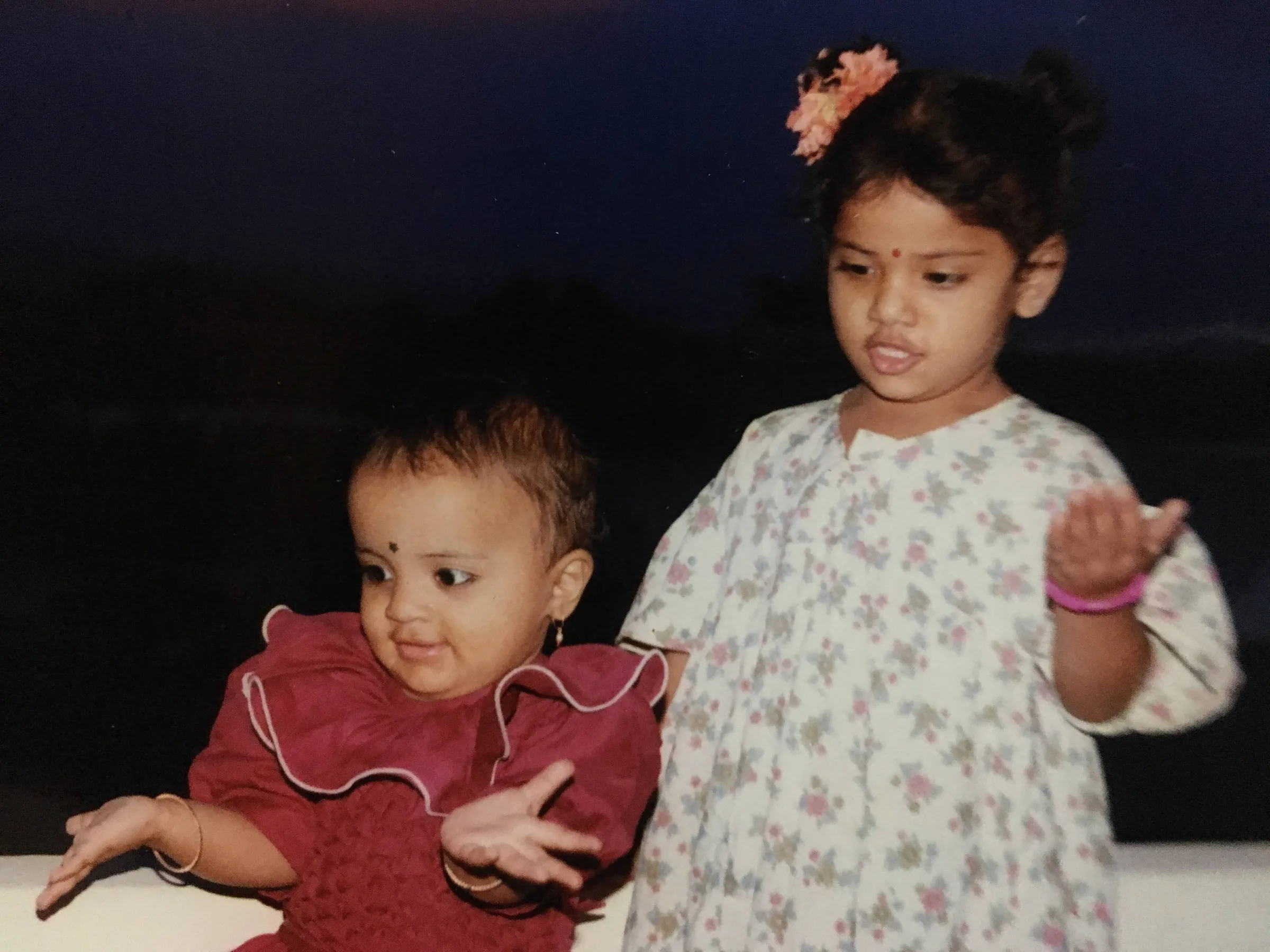 A faded old photograph of two small children, one of them still a baby.