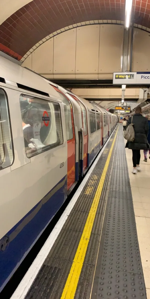 An empty Underground platform with a train waiting, doors open.