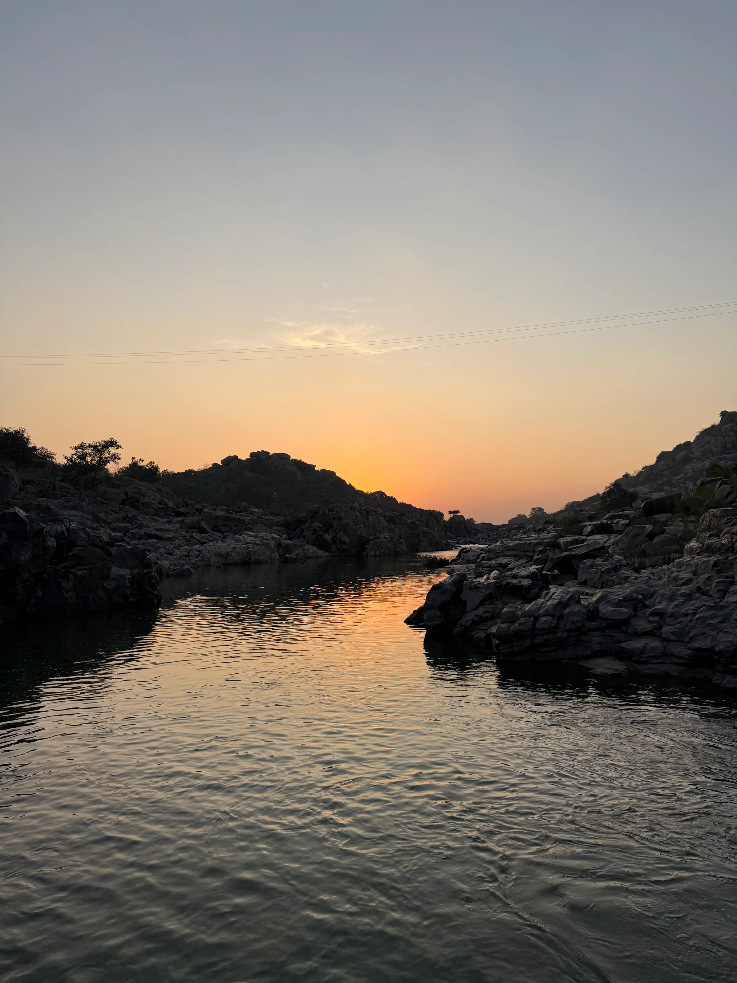 Sunset burning gold across a rocky river.